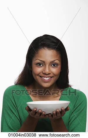 Young woman holding white bowl and smiling View Large Photo Image Stock Photo - Young woman holding white bowl and smiling. Fotosearch