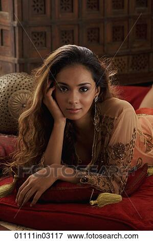 Young woman laying on pillows looking at camera View Large Photo Image Stock Photo - Young woman laying on pillows looking at camera. Fotosearch