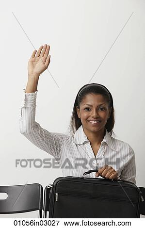Stock Photo - Young woman raises her hand and smiles. Fotosearch