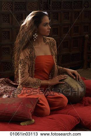 Young woman relaxing on pillows with Indian antiques View Large Photo Image Stock Image - Young woman relaxing on pillows with Indian antiques. Fotosearch