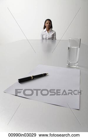 Young woman sits at end of the table waiting to be interviewed View Large Photo Image Stock Photo - Young woman sits at end of the table waiting to be interviewed. Fotosearch