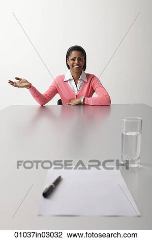 Young woman sitting at end of table being interviewed View Large Photo Image Stock Image - Young woman sitting at end of table being interviewed. Fotosearch
