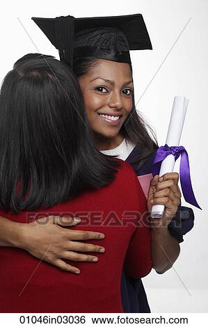 Young woman wearing cap and gown and hugging another person View Large Photo Image Stock Photograph - Young woman wearing cap and gown and hugging another person. Fotosearch