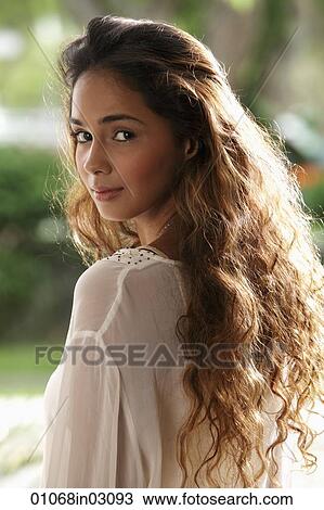 Young woman with long hair looking over her shoulder View Large Photo Image Stock Image - Young woman with long hair looking over her shoulder. Fotosearch