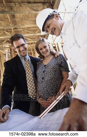 Architect discussing blueprints with a mid adult couple View Large Photo Image Stock Image - Architect discussing blueprints with a mid adult couple. Fotosearch