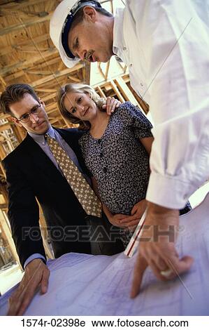 Architect discussing blueprints with a mid adult couple View Large Photo Image Stock Image - Architect discussing blueprints with a mid adult couple. Fotosearch