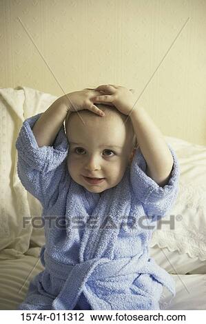 Stock Image - Baby boy wearing a blue bathrobe. Fotosearch