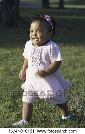 Stock Image - Baby girl walking in a park. Fotosearch