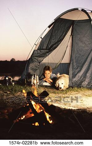 Boy camping in a tent with his dog View Large Photo Image Stock Image - Boy camping in a tent with his dog. Fotosearch
