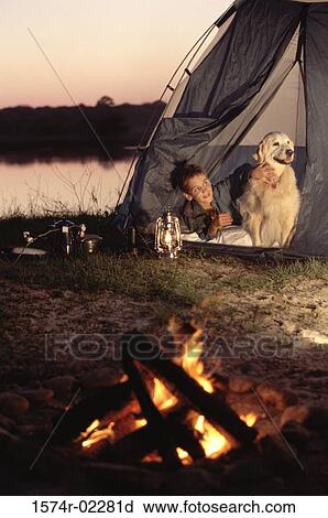 Boy camping in a tent with his dog View Large Photo Image Stock Image - Boy camping in a tent with his dog. Fotosearch