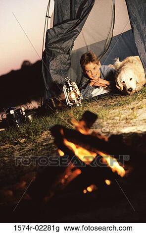 Boy camping in a tent with his dog View Large Photo Image Stock Image - Boy camping in a tent with his dog. Fotosearch