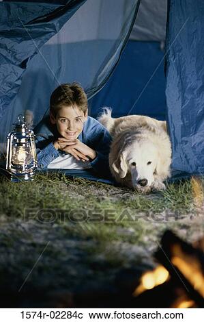 Boy camping in a tent with his dog View Large Photo Image Stock Image - Boy camping in a tent with his dog. Fotosearch