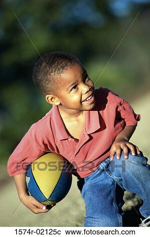 Boy kneeling with a rugby ball View Large Photo Image Stock Image - Boy kneeling with a rugby ball. Fotosearch