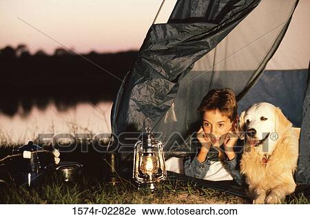 Boy lying in a tent with his dog View Large Photo Image Stock Image - Boy lying in a tent with his dog. Fotosearch