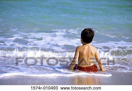 Boy sitting at the beach View Large Photo Image Stock Image - Boy sitting at the beach. Fotosearch