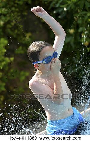 Boy splashing in water in a swimming pool View Large Photo Image Stock Photo - Boy splashing in water in a swimming pool. Fotosearch