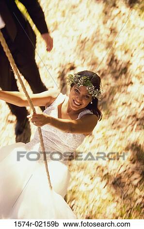 Stock Image - Bride sitting on a swing. Fotosearch