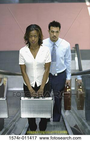 Businessman and a businesswoman on an escalator View Large Photo Image Stock Photo - Businessman and a businesswoman on an escalator. Fotosearch