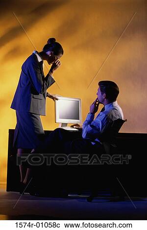 Businessman and a businesswoman using a computer View Large Photo Image Stock Image - Businessman and a businesswoman using a computer. Fotosearch
