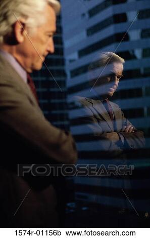 Stock Image - Businessman looking out of a window. Fotosearch