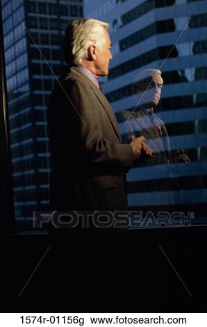 Businessman looking out of a window View Large Photo Image Stock Image - Businessman looking out of a window. Fotosearch