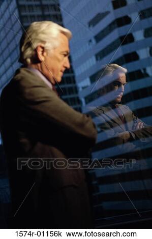 Stock Image - Businessman looking out of a window. Fotosearch