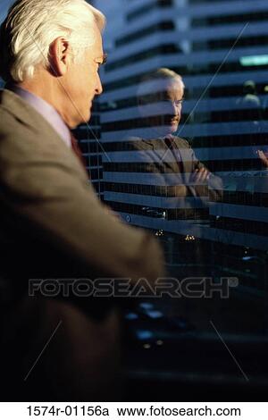 Stock Image - Businessman looking through a window. Fotosearch