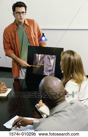 Stock Image - Businessman pointing to a computer monitor during a presentation. Fotosearch