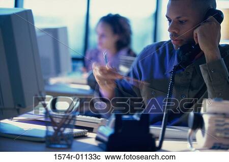 Businessman talking on a landline telephone View Large Photo Image Stock Image - Businessman talking on a landline telephone. Fotosearch