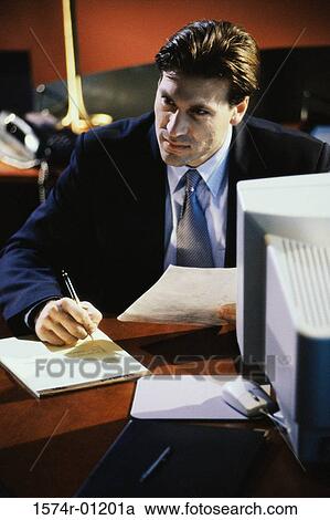 Stock Image - Businessman writing in a notepad. Fotosearch
