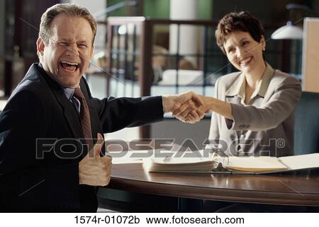 Businesswoman and a businessman shaking hands View Large Photo Image Stock Image - Businesswoman and a businessman shaking hands. Fotosearch