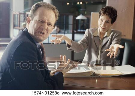 Businesswoman and a businessman discussing in an office View Large Photo Image Stock Image - Businesswoman and a businessman discussing in an office. Fotosearch