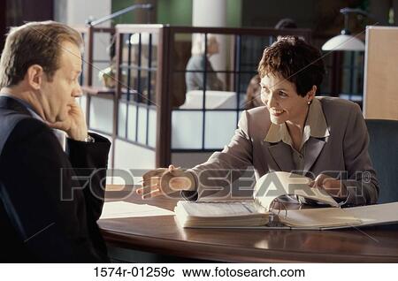 Businesswoman and a businessman discussing in an office View Large Photo Image Stock Image - Businesswoman and a businessman discussing in an office. Fotosearch