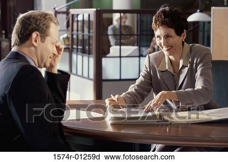 Businesswoman and a businessman discussing in an office View Large Photo Image Stock Image - Businesswoman and a businessman discussing in an office. Fotosearch