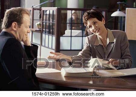 Businesswoman and a businessman discussing in an office View Large Photo Image Stock Image - Businesswoman and a businessman discussing in an office. Fotosearch