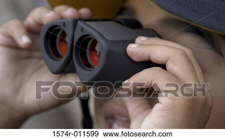 Stock Photo - Close-up of a boy holding a pair of binoculars. Fotosearch