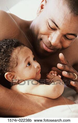 Stock Image - Close-up of a father holding his baby boy. Fotosearch