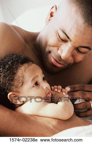 Stock Image - Close-up of a father holding his baby boy. Fotosearch