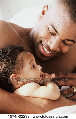 Close-up of a father holding his baby boy View Large Photo Image Stock Image - Close-up of a father holding his baby boy. Fotosearch