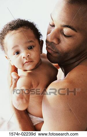 Stock Image - Close-up of a father holding his baby boy. Fotosearch