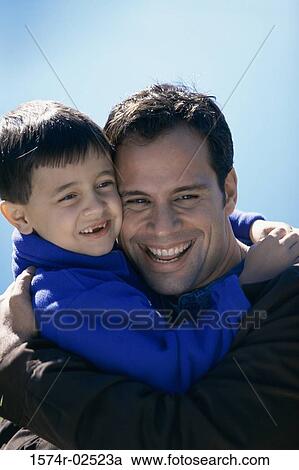 Close-up of a father hugging his son View Large Photo Image Stock Image - Close-up of a father hugging his son. Fotosearch