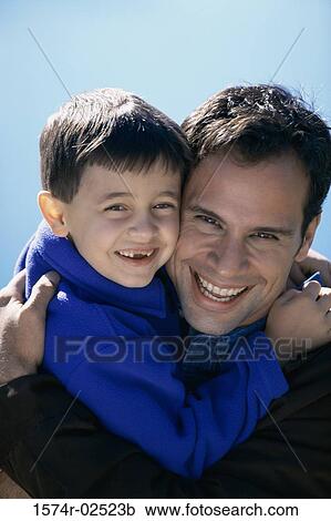 Close-up of a father hugging his son View Large Photo Image Stock Image - Close-up of a father hugging his son. Fotosearch