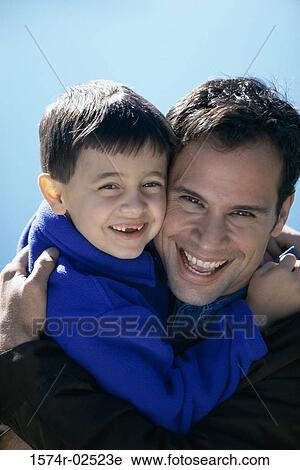 Stock Image - Close-up of a father hugging his son. Fotosearch