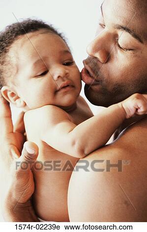 Close-up of a father kissing his baby boy View Large Photo Image Stock Image - Close-up of a father kissing his baby boy. Fotosearch