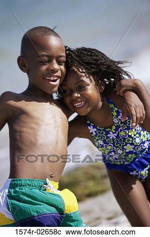Close-up of a girl and a boy holding each other on the beach View Large Photo Image Stock Image - Close-up of a girl and a boy holding each other on the beach. Fotosearch