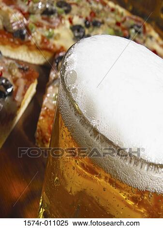 Close-up of a glass of beer and a sliced pizza View Large Photo Image Stock Photography - Close-up of a glass of beer and a sliced pizza. Fotosearch