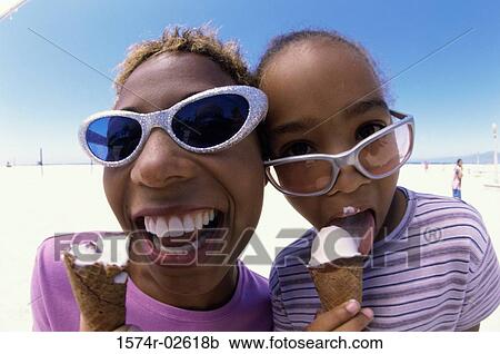 Close-up of a mother and her daughter holding ice cream cones View Large Photo Image Stock Image - Close-up of a mother and her daughter holding ice cream cones. Fotosearch