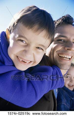 Close-up of a son riding piggyback on his father View Large Photo Image Stock Image - Close-up of a son riding piggyback on his father. Fotosearch