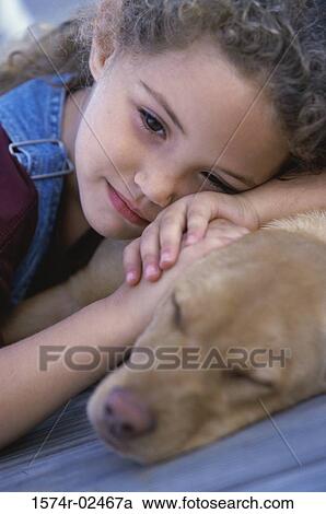 Close-up of a young girl lying with her dog View Large Photo Image Stock Image - Close-up of a young girl lying with her dog. Fotosearch