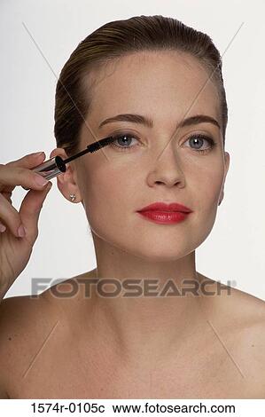 Stock Image - Close-up of a young woman applying mascara. Fotosearch